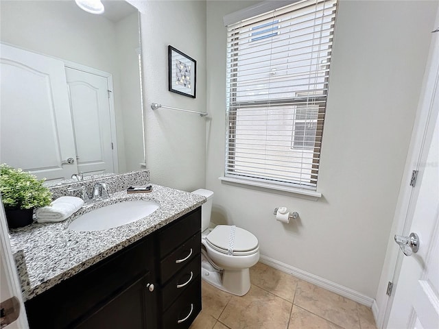 bathroom featuring tile patterned flooring, toilet, and vanity