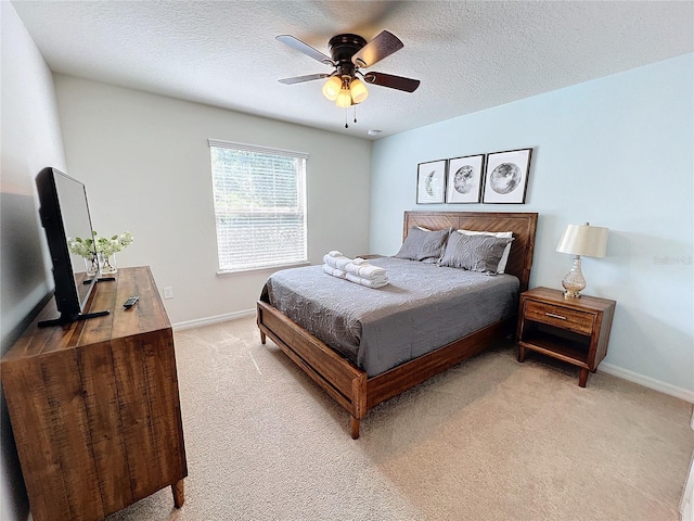 bedroom with a textured ceiling, ceiling fan, and light colored carpet