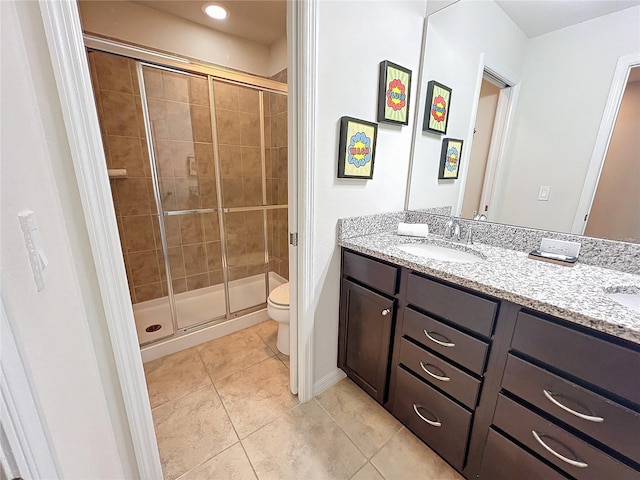 bathroom with dual vanity, tile patterned floors, toilet, and an enclosed shower