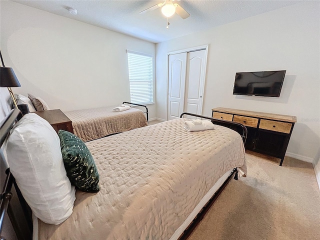 bedroom featuring carpet flooring, a textured ceiling, ceiling fan, and a closet