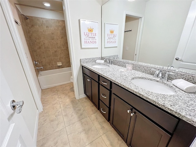 full bathroom featuring double vanity, tiled shower / bath, toilet, and tile patterned floors