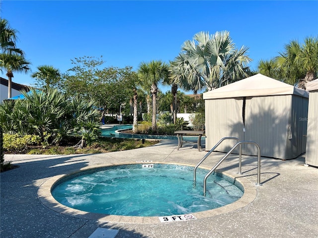 view of swimming pool featuring a hot tub