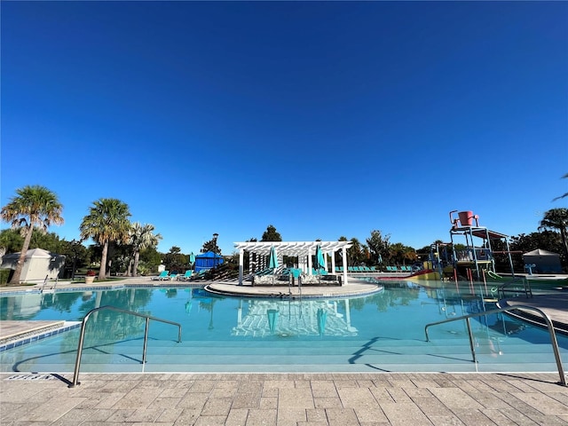 view of swimming pool featuring a water slide and a pergola