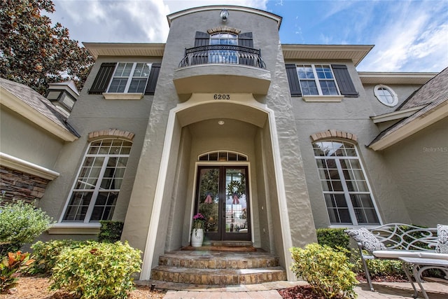 property entrance with a balcony and french doors