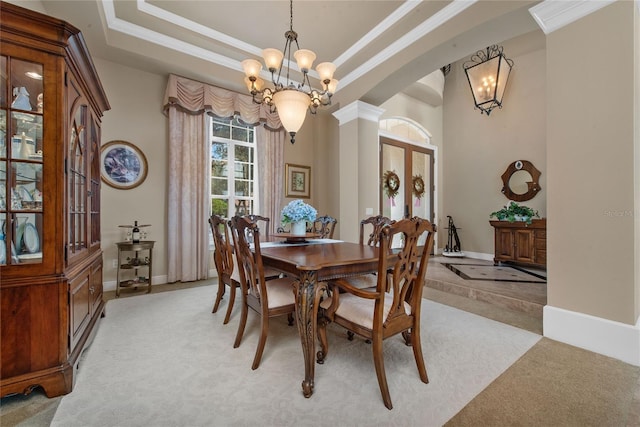 dining area featuring ornamental molding, french doors, a tray ceiling, and light carpet