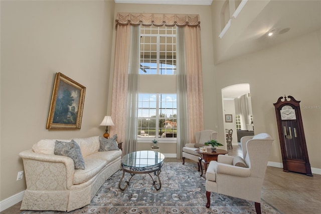 living area with tile patterned flooring and a high ceiling