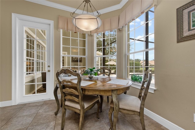 tiled dining area with baseboards and crown molding