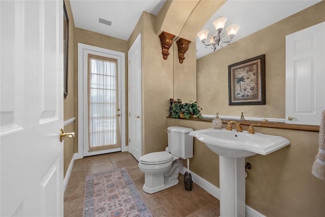 half bath featuring toilet, baseboards, visible vents, and tile patterned floors