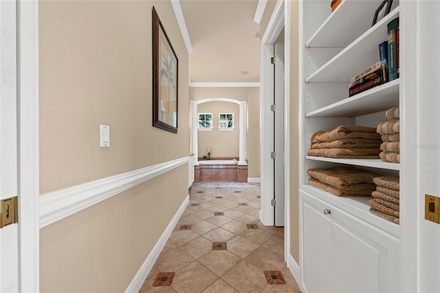 hallway with light tile patterned flooring and crown molding