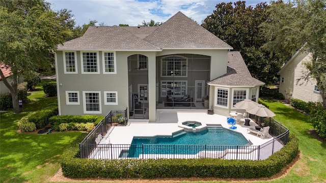 rear view of house featuring a shingled roof, stucco siding, a yard, and a patio