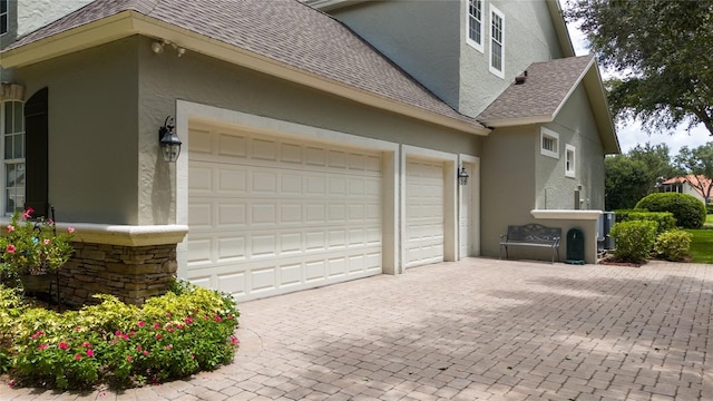 garage featuring decorative driveway