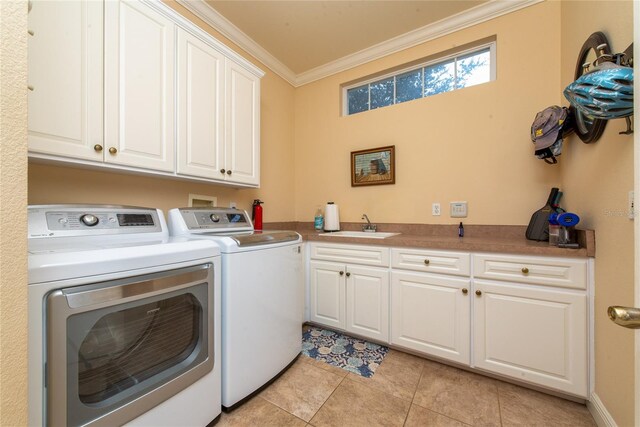 laundry room featuring washing machine and clothes dryer, sink, cabinets, crown molding, and light tile patterned flooring