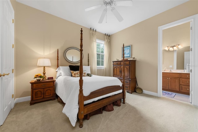 bedroom with a ceiling fan, baseboards, connected bathroom, and light colored carpet