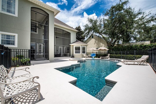 view of swimming pool featuring a pool with connected hot tub, a patio, and fence