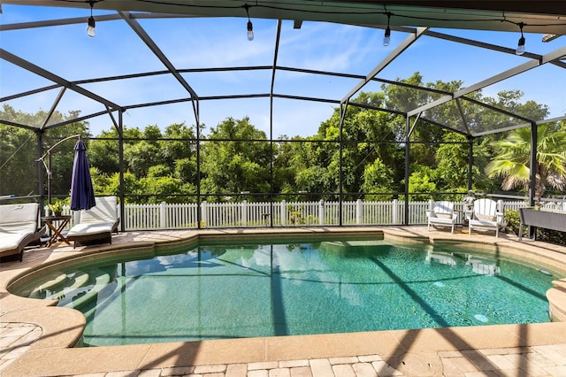 view of pool with glass enclosure, a patio area, fence, and a fenced in pool