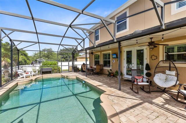 view of swimming pool with french doors, a lanai, a patio area, and ceiling fan