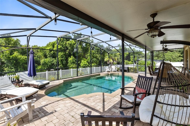 view of pool with glass enclosure, ceiling fan, and a patio area