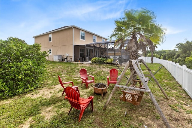 view of yard featuring glass enclosure and a fire pit