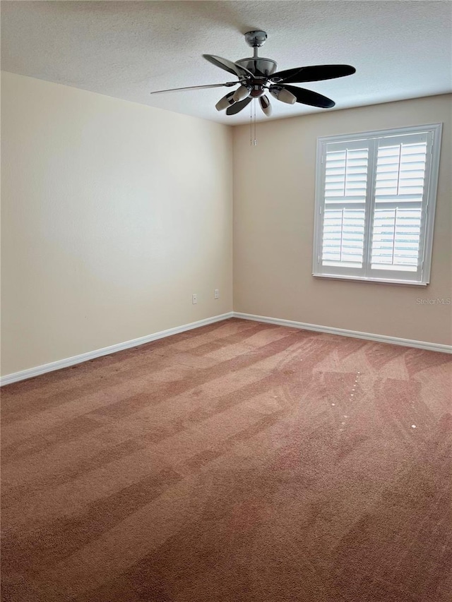 carpeted spare room featuring ceiling fan and a textured ceiling