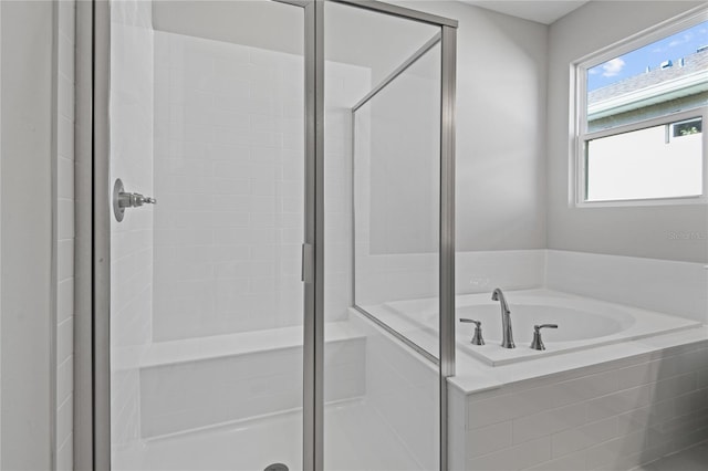 bathroom featuring shower with separate bathtub