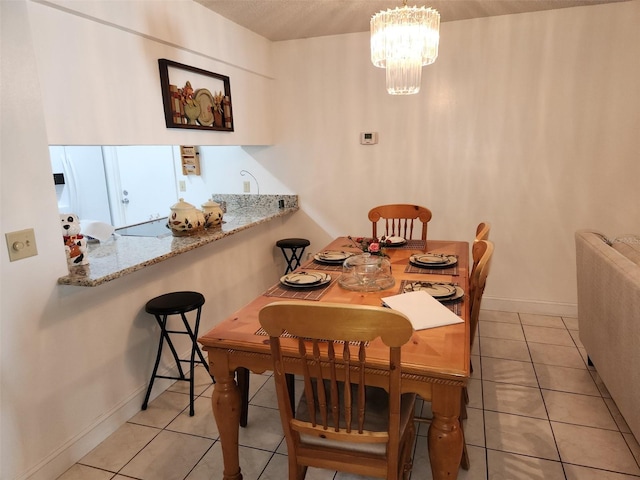 tiled dining space with a chandelier