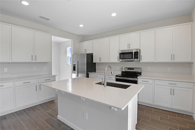 kitchen with white cabinetry, stainless steel appliances, and dark wood-type flooring