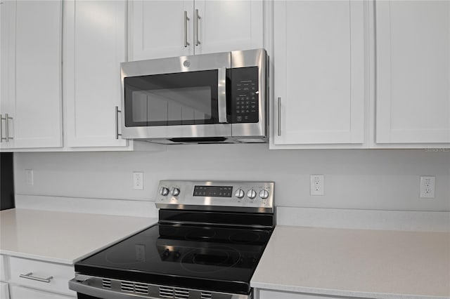 kitchen with appliances with stainless steel finishes and white cabinetry