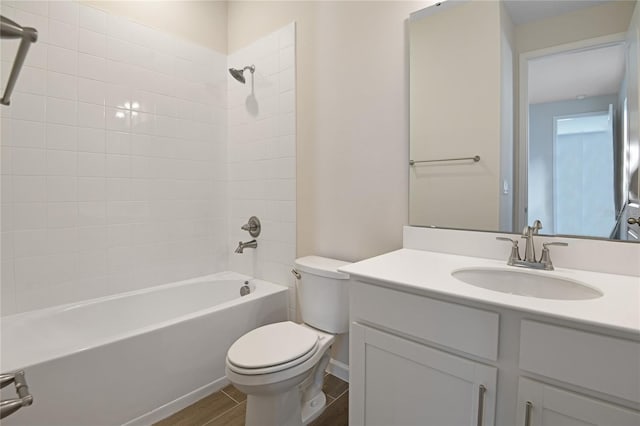 full bathroom with vanity, hardwood / wood-style flooring, toilet, and tiled shower / bath