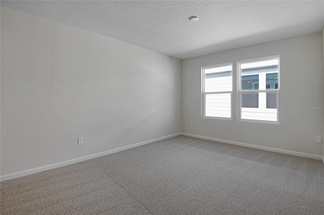 carpeted spare room featuring a textured ceiling