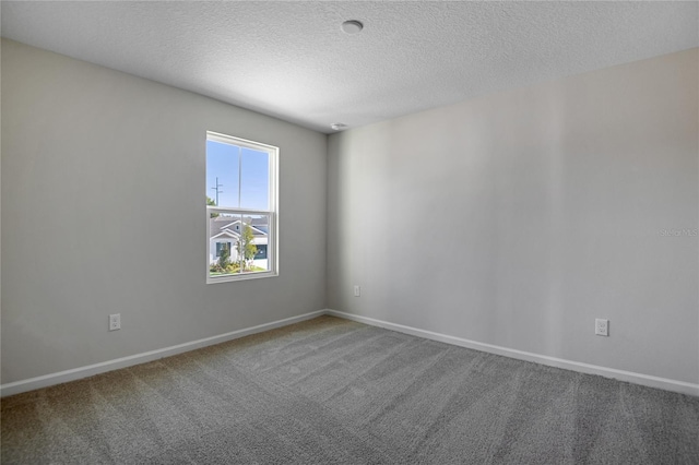 carpeted spare room featuring a textured ceiling