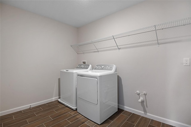 clothes washing area with washing machine and dryer and dark wood-type flooring