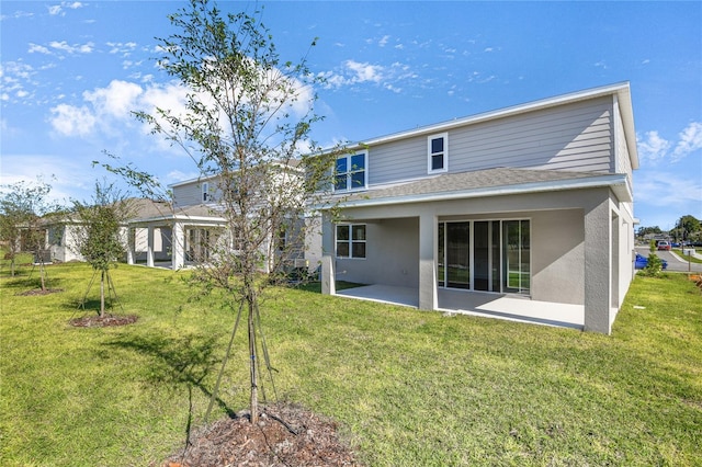 rear view of house featuring a lawn and a patio area