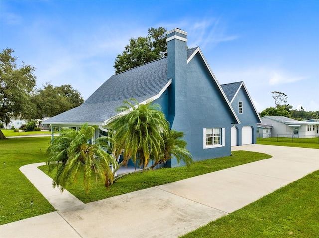 view of side of property featuring a garage and a lawn