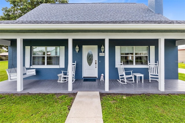 doorway to property with a yard and covered porch