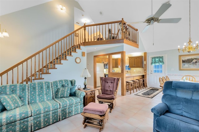 living room with ceiling fan with notable chandelier and high vaulted ceiling