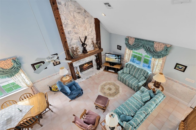 living room featuring ceiling fan, high vaulted ceiling, a stone fireplace, and tile patterned floors