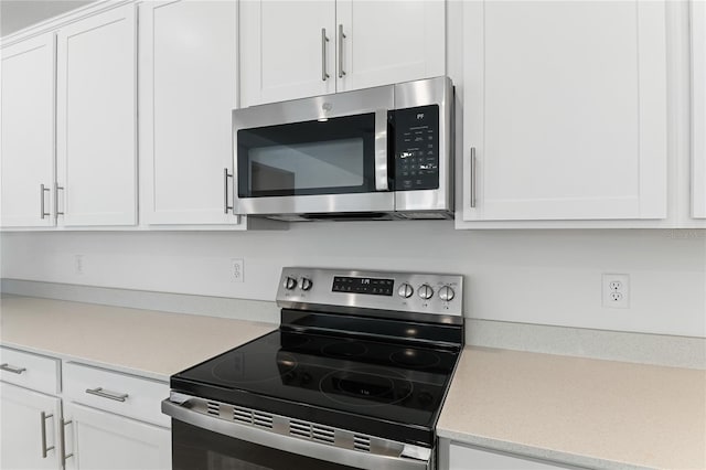 kitchen featuring stainless steel appliances and white cabinetry