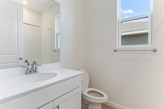 bathroom with vanity, walk in shower, and toilet