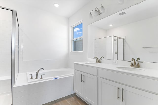 bathroom featuring shower with separate bathtub and vanity