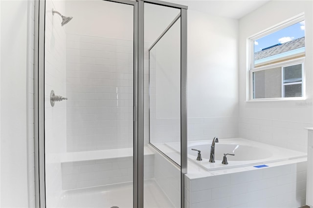 bathroom featuring shower with separate bathtub