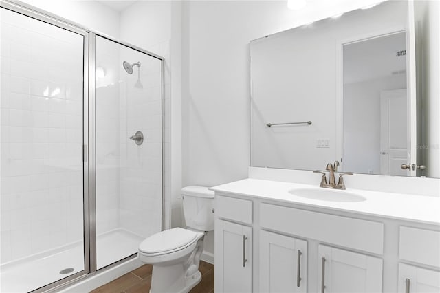 bathroom with an enclosed shower, vanity, wood-type flooring, and toilet