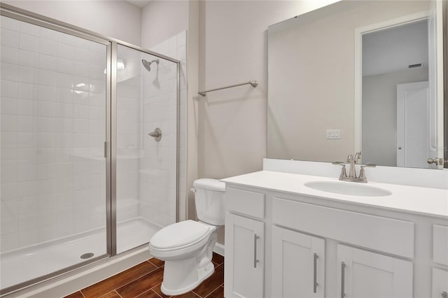 bathroom with vanity, a shower with shower door, and toilet