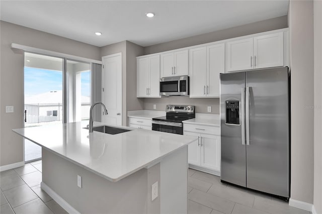 kitchen featuring appliances with stainless steel finishes, sink, a center island with sink, and white cabinets