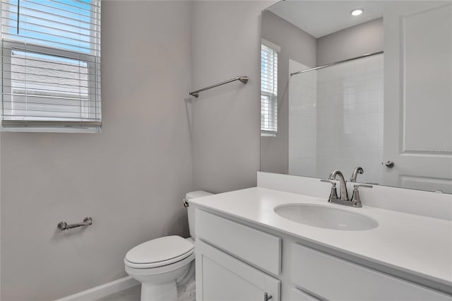 bathroom with vanity, toilet, and a shower