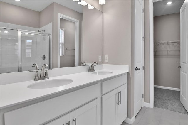 bathroom featuring a shower with door, vanity, and tile patterned floors