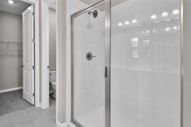 bathroom with walk in shower, tile patterned floors, and toilet