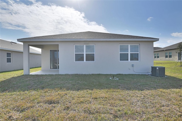 rear view of house featuring central AC unit, a yard, and a patio