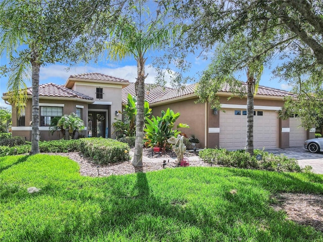 mediterranean / spanish house featuring a front yard and a garage