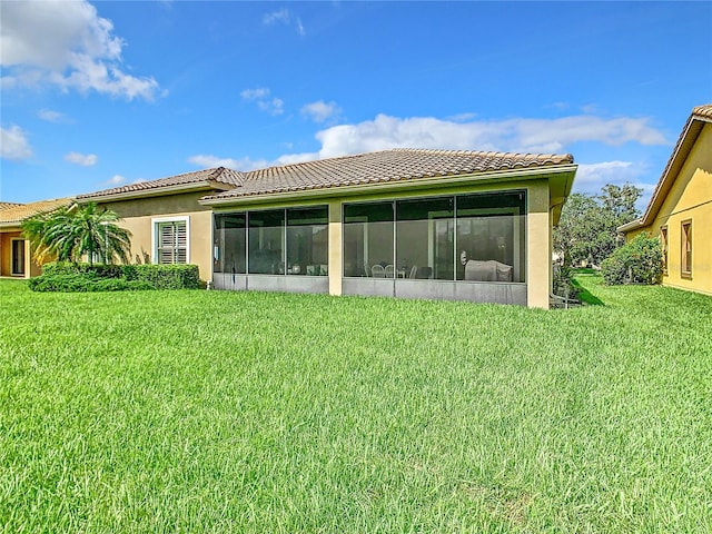 rear view of house with a sunroom and a yard