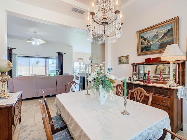 dining space with light tile patterned flooring and ceiling fan with notable chandelier